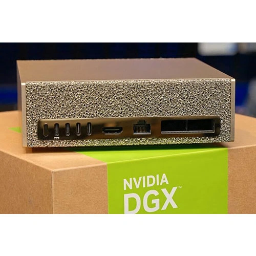 940-54242-0008-000-image-01 Front view of a textured metal server module with multiple i/o ports, sitting on an nvidia dgx box.