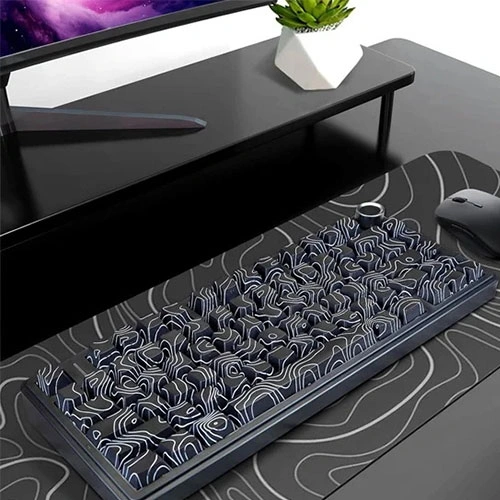 Aula-f75-wireless-tri-mode-rgb-75-percent-mechanical-gaming-keyboard-with-star-vector-switch-8 Mechanical keyboard with blue and white patterned keycaps on a desk mat, in front of a monitor; a small potted plant on the desk.